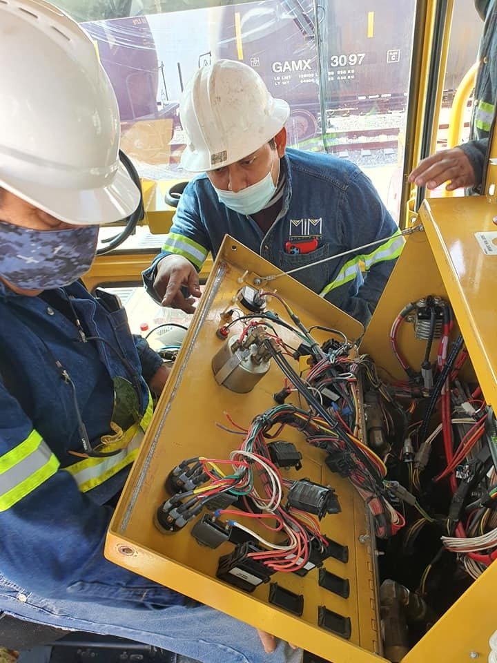 Técnicos MIM Monterrey realizando mantenimiento eléctrico en equipo ferroviario